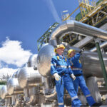 Two Oilfield Workers Inspecting Oil Refinery