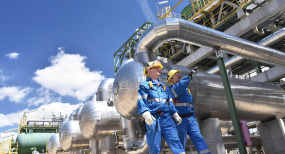 Two Oilfield Workers Inspecting Oil Refinery